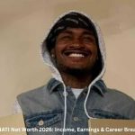 SoLLUMINATI Net Worth – SoLLUMINATI smiling while wearing a hoodie and denim vest during a content shoot in 2026.