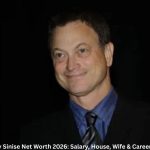 Gary Sinise smiling in a formal black suit and blue shirt, Gary Sinise Net Worth 2026 feature image