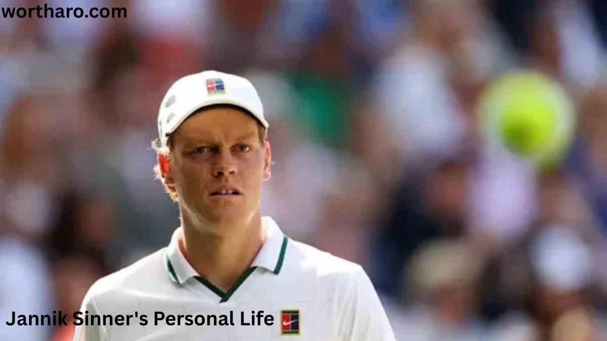 Jannik Sinner wearing a white tennis outfit and cap during a match, featured in Jannik Sinner Net Worth 2026.