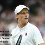 Jannik Sinner wearing a white outfit and Nike cap during a tennis match, featured in Jannik Sinner Net Worth 2026.